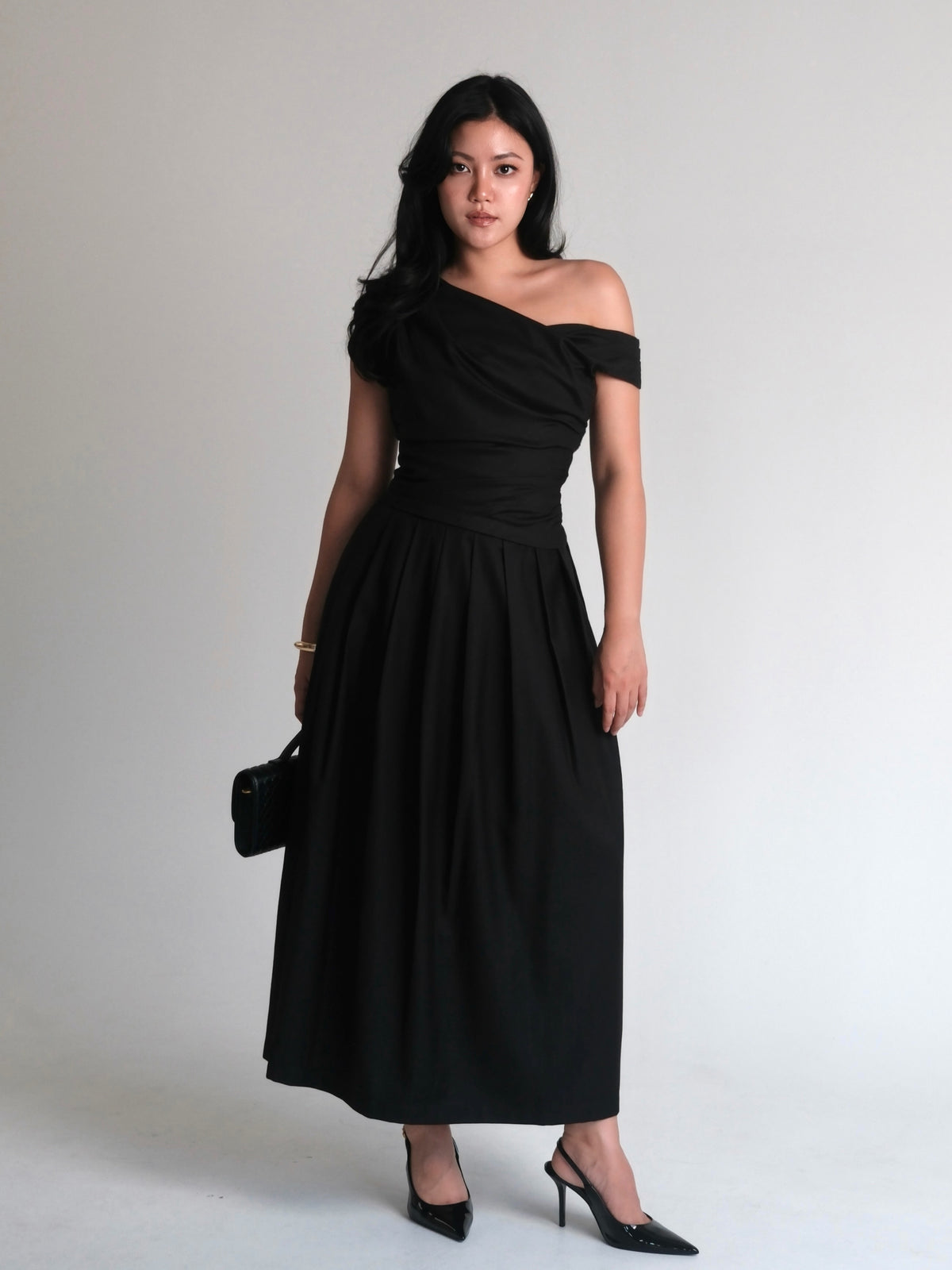 A mood in black.Powerful, feminine, and effortlessly refined. A silhouette designed to flatter, with soft draping and...