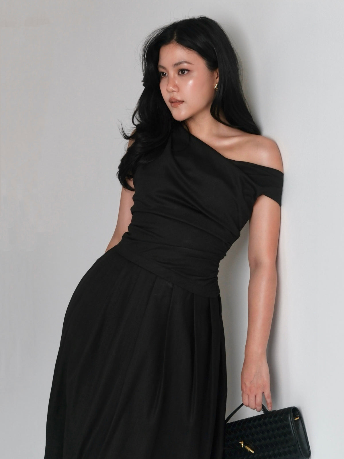 A mood in black.Powerful, feminine, and effortlessly refined. A silhouette designed to flatter, with soft draping and...