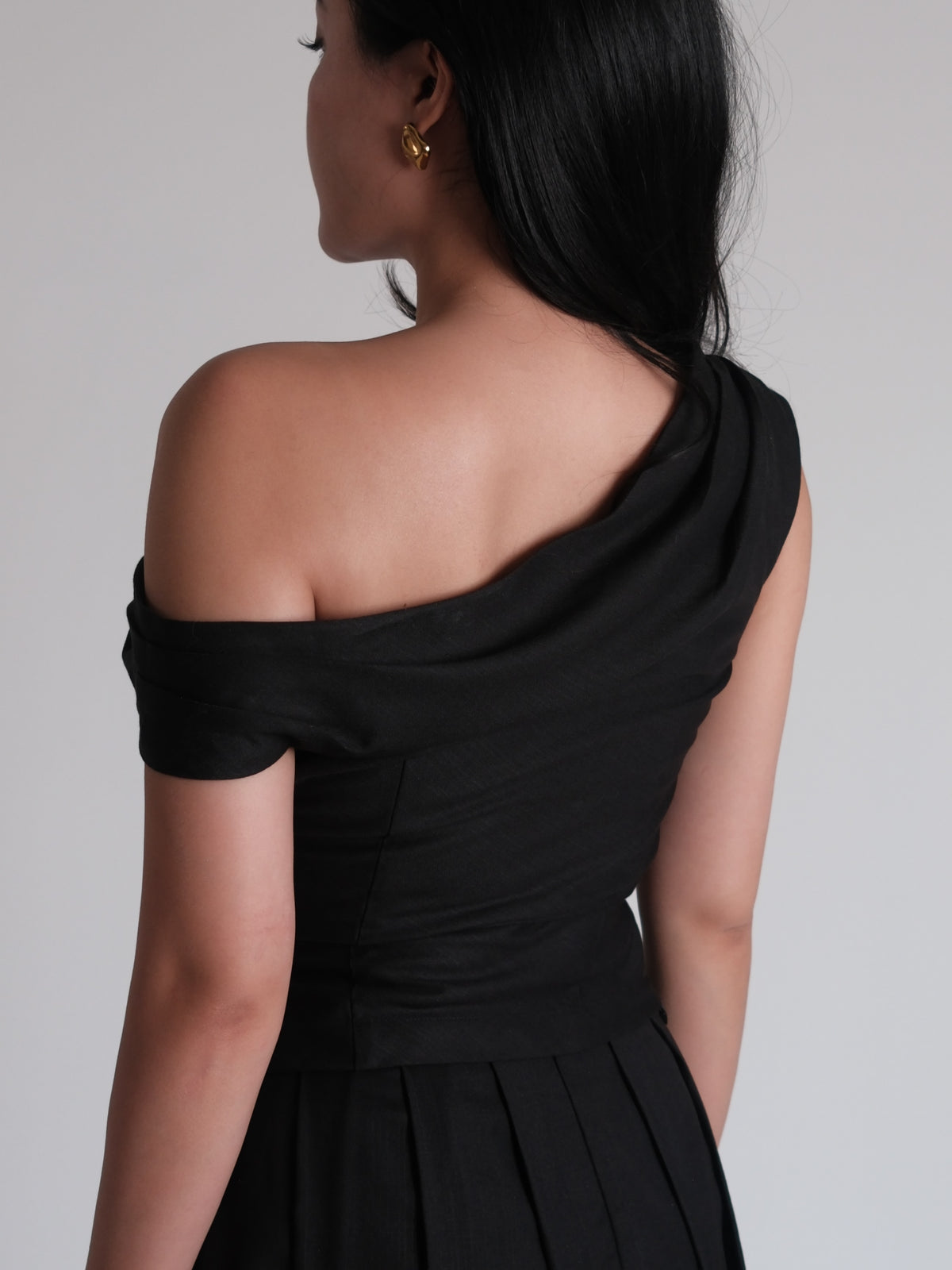 A mood in black.Powerful, feminine, and effortlessly refined. A silhouette designed to flatter, with soft draping and...