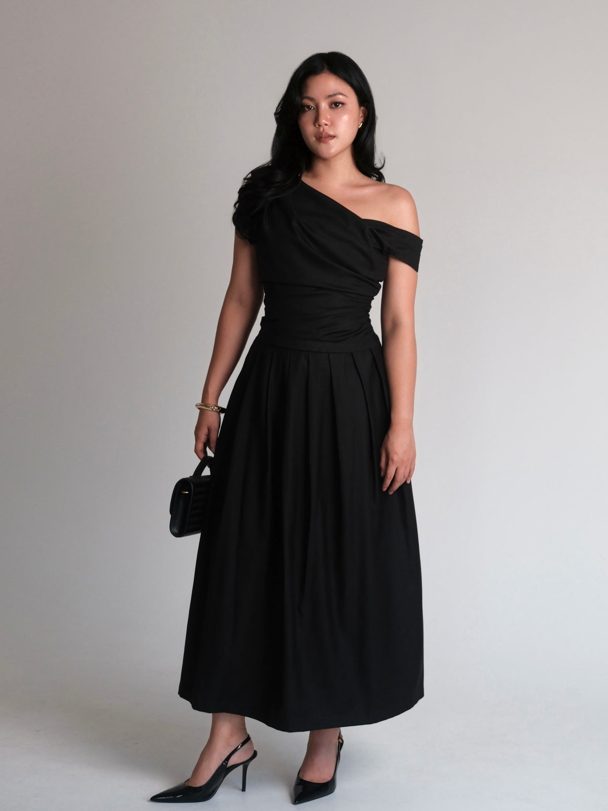A mood in black.Powerful, feminine, and effortlessly refined. A silhouette designed to flatter, with soft draping and...